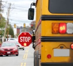 School bus with stop arm extended and red lights flashing for G1 practice test preparation - CanDriveHub